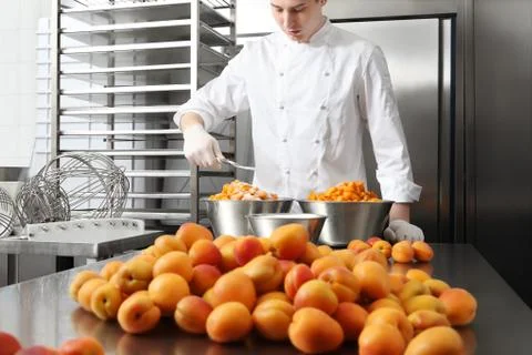 Pastry chef at work in professional kitchen, makes apricot jam for the cake o Stock-Fotos