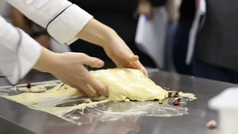 The pastry chef works with a batch of dough on the working surface. Slow motion. Stock Footage 121034840