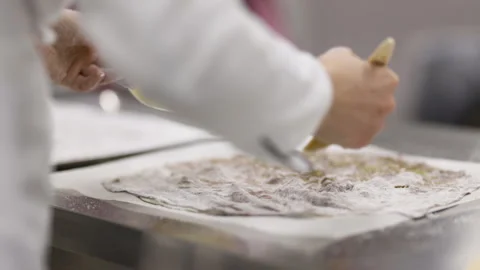 The pastry chef works with a batch of dough on the working surface. Stock Footage 121034926