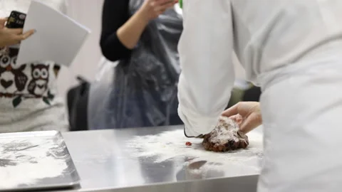 The pastry chef works with a batch of dough on the working surface. Slow motion. Stock Footage 121044493