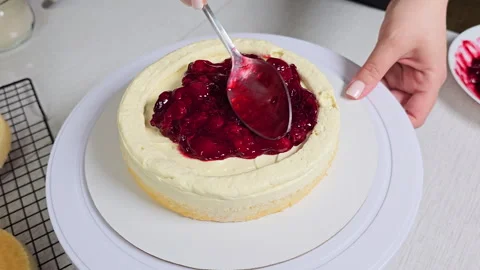 The pastry chef's hands decorate the cake with cream Stock Footage 240279872