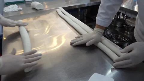Pastry Chefs Rolling Long Dough Ropes on Metal Countertop Stock Footage 345291834