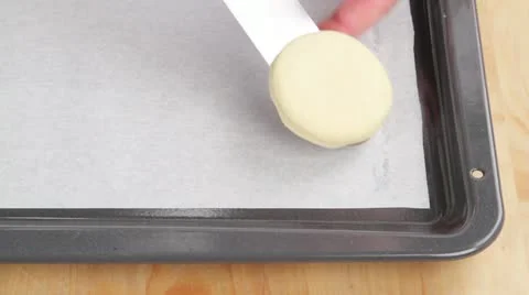 Pastry circles (for scones) being placed on a baking tray lined with Stock Footage 24655363