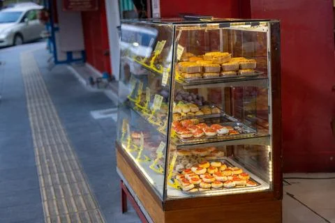 Pastry display case on sidewalk bakery Bangkok Chinatown Foto stock