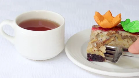 Pastry piece slice of cake rectangle shape on white plate and black tea in cup Stock Footage 218787527
