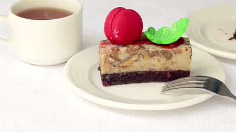 Pastry piece slice of cake rectangle shape on white plate and black tea in cup Stock Footage 218791562