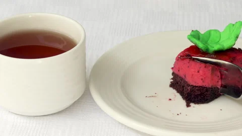 Pastry piece slice of cake rectangle shape on white plate and black tea in cup 스톡 동영상 229462088