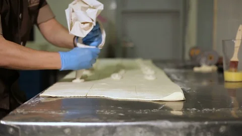 The pastry spread cheese filling over the dough in the kitchen Video stock 106475053