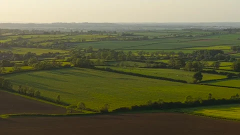 Pasture fields countryside panorama beneath warm sunset light in late spring Stock Footage 345714709
