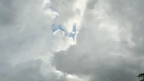 A patch of blue sky breaks through thick gray storm clouds Stock Footage 336362118