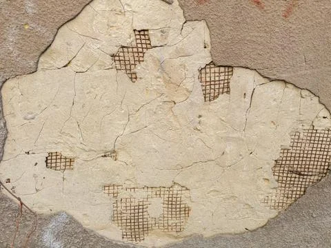 Patch of crumbling plaster with bare reinforcement in retaining wall Foto stock