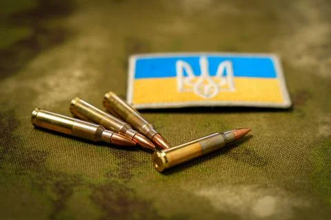 Patch with the flag and coat of arms of Ukraine, rifle cartridges on a camouf Stock Photos