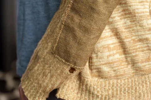 Patch on a man wool sweater. Mending clothes we sew, wear, repair. Selective  Stock Photos