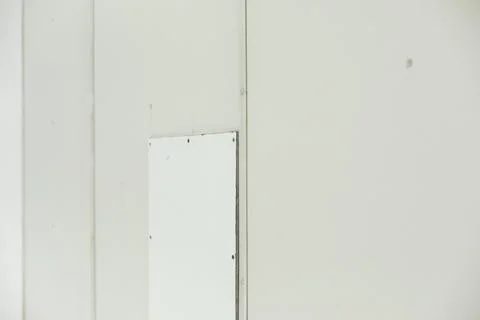 Patch on wall. Texture of white wall with inserts. Broken surface. Stock Photos