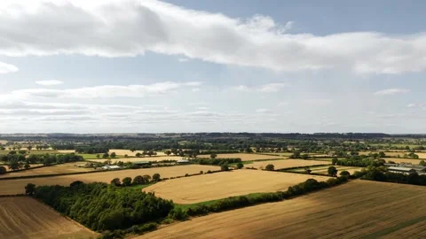 Patchwork agricultural fields with rural countryside under dramatic summer Vídeos de archivo 347264718