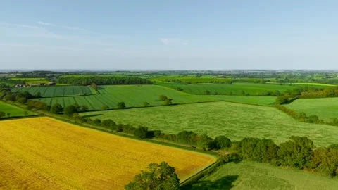 Patchwork agricultural landscape spreading across fertile countryside hills 動画素材 339342620