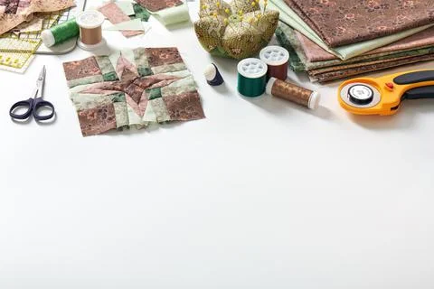 Patchwork block, stack of fabrics, sewing and quilting accessories. Copy space Fotos de archivo