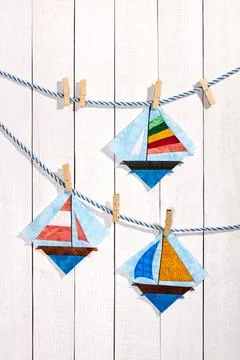 Patchwork blocks attached with clothespins on a rope on a white wooden back.. 스톡 사진