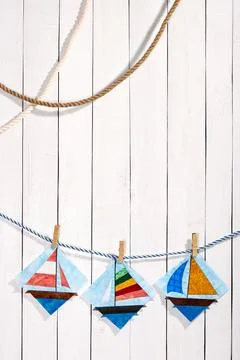 Patchwork blocks attached with clothespins on a rope on a white wooden back.. Stock-Fotos