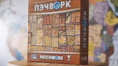 Patchwork board game against a blurry world map. The camera flies around Stock Footage 160560806