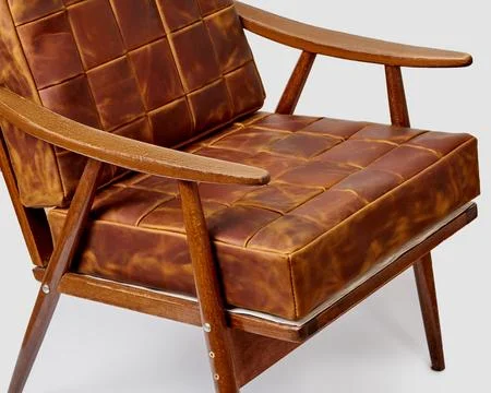 Patchwork brown leather cushions complementing vintage wooden chair Stock Photos