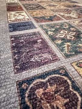 Patchwork carpet pattern with varied floral designs in a textured background Foto stock