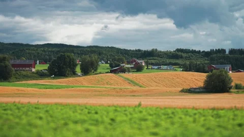 A patchwork of farm fields in rural Norway Stormy clouds whirl above. Stock Footage 270530956
