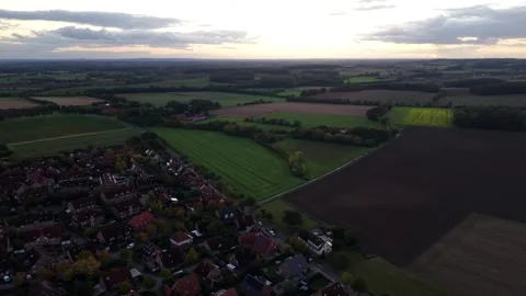 Patchwork farm fields stretch beyond red-roofed American neighborhood, hazy Stock Footage 348083124