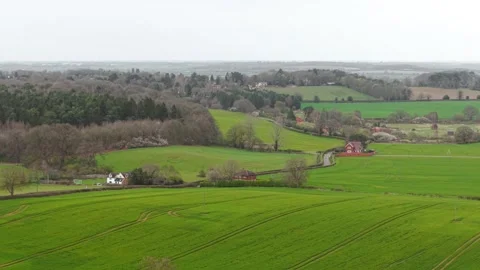 Patchwork farmland panorama with village settlement and rolling green fields Stock Footage 334041562