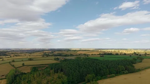 Patchwork farmland surrounding rural farmstead in open countryside landscape Stock Footage 342806100