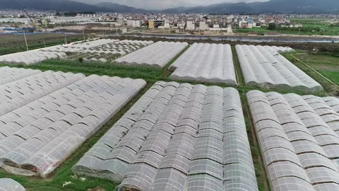 Patchwork Fields and Farmhouses Surrounded by Hills Stock Footage 304315373