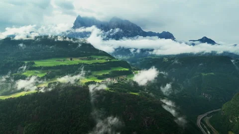 Patchwork fields and forest strips facing the Catinaccio massif, aerial Stock Footage 319909616