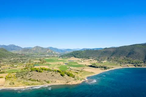 Patchwork fields by blue sea and forested hills 写真素材