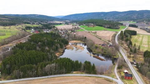 Patchwork fields dense evergreen forests surround reflective pond panorama Stock Footage 327624351