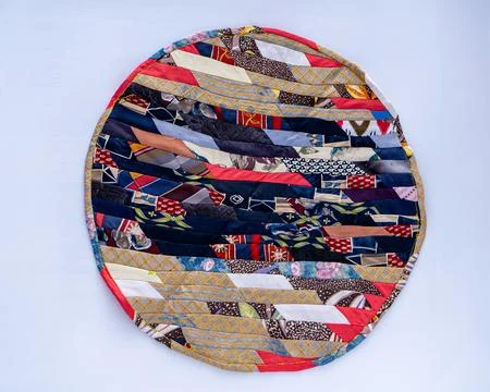 Patchwork. A fragment of multi-colored pieces of fabric sewn together. Round rug Fotos de archivo
