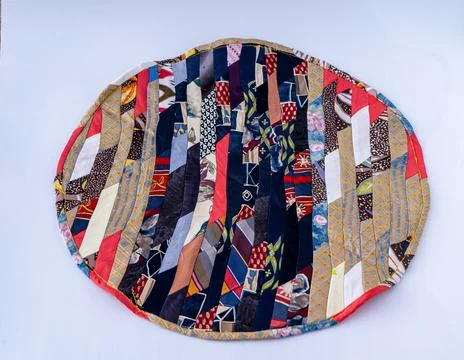 Patchwork. A fragment of multi-colored pieces of fabric sewn together. Round Stock Photos