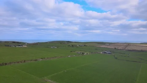 A patchwork of green fields, a rural road with cars and blue sky with Stock Footage 171513084