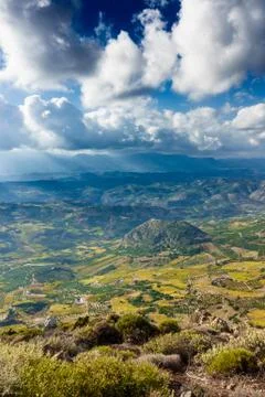 Patchwork landscape and mountain against cloudy sky Fotos de archivo