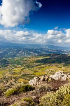 Patchwork landscape and mountain against cloudy sky 스톡 사진