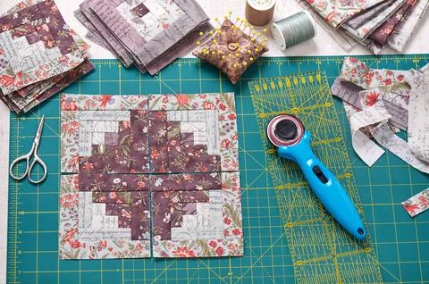 Patchwork log cabin blocks on craft mat, stack of blocks, sewing accessories 스톡 사진