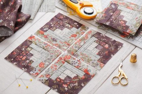 Patchwork log cabin blocks, stack of blocks, sewing accessories on white wo.. Fotos de archivo