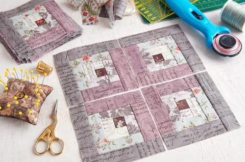 Patchwork log cabin blocks, stack of blocks, sewing accessories on white wo.. Fotos de archivo