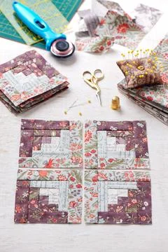 Patchwork log cabin blocks, stack of blocks, sewing accessories on white wo.. Stock Photos