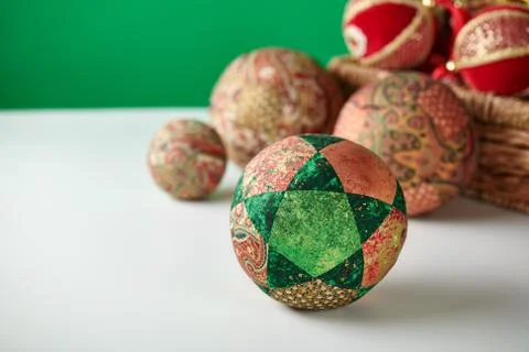 Patchwork puzzle balls and christmas decorations in basket on white and green Stock-Fotos