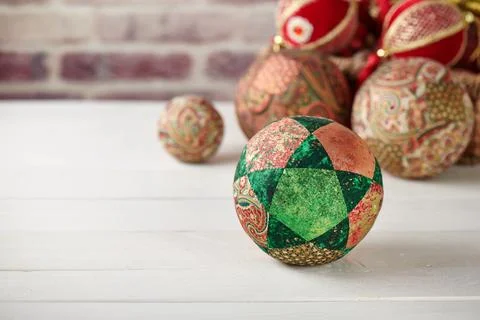 Patchwork puzzle balls and christmas decorations in basket on brick wall ba.. Fotos de archivo