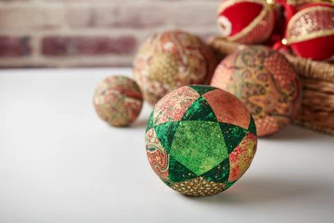 Patchwork puzzle balls and christmas decorations in basket on brick wall ba.. Fotos de archivo