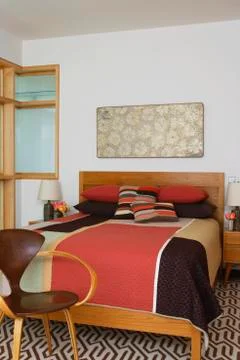 Patchwork Quilt On Bed By Chair Foto stock