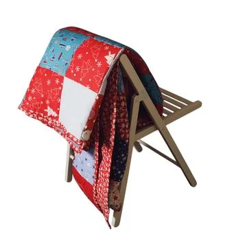 Patchwork quilt with Christmas pattern draped over a wooden chair. Textile .. Fotos de archivo