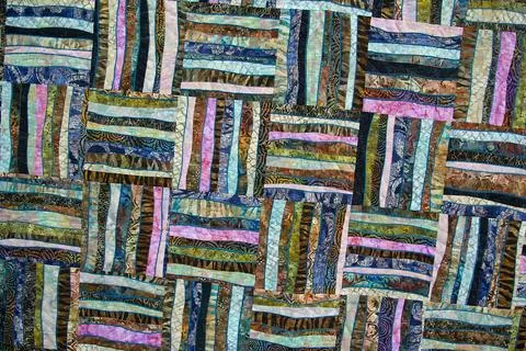 A patchwork quilt with many different colored squares Stock Photos