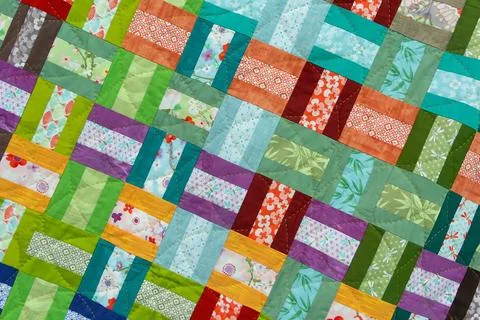 A patchwork quilt with many different colored squares Stock Photos